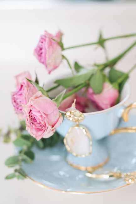 A classic floral arrangement of pink roses in a vintage tea cup, exuding elegance and romance.