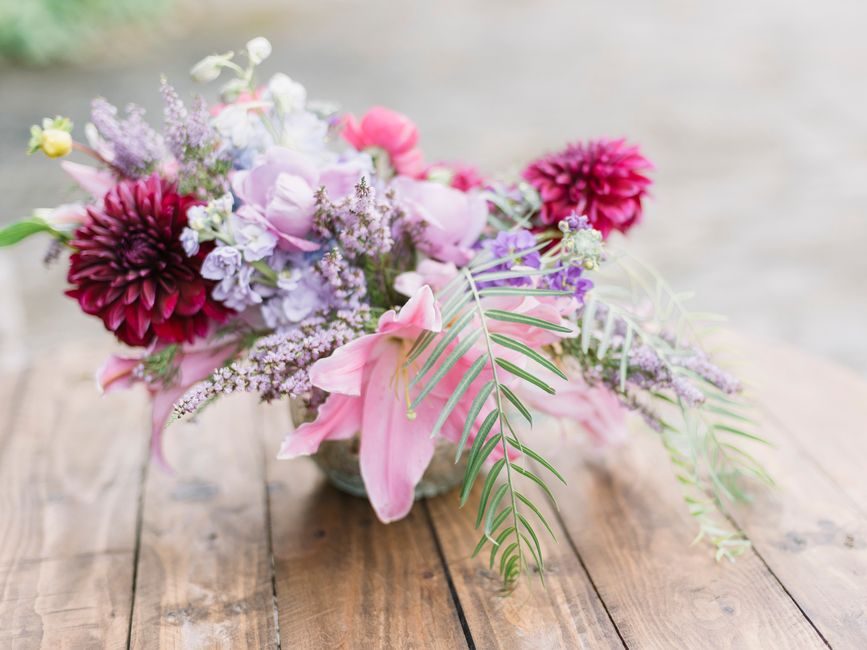 Vibrant bouquet of assorted flowers elegantly arranged on a rustic wooden table.