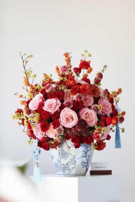 Stunning floral arrangement with red and pink roses in a decorative vase, perfect for elegant interior decor.