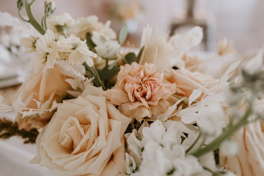 Bunch of fresh delicate flowers with green branches placed on table at romantic occasion