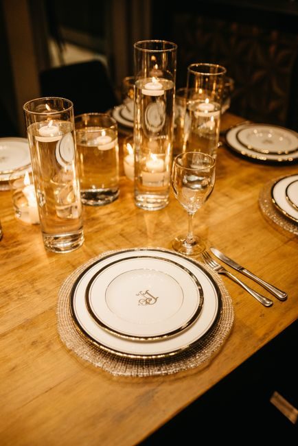 A beautifully set dining table with candles and glassware creating a warm, inviting atmosphere.