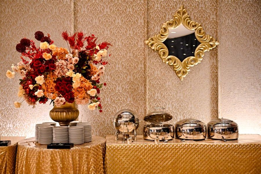 Lavish buffet setup with floral decor and chafing dishes in an elegant Bandung banquet hall.