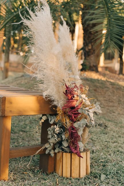 Beautiful pampas grass and dried flower arrangement placed on a wooden table outdoors, perfect for event decor.