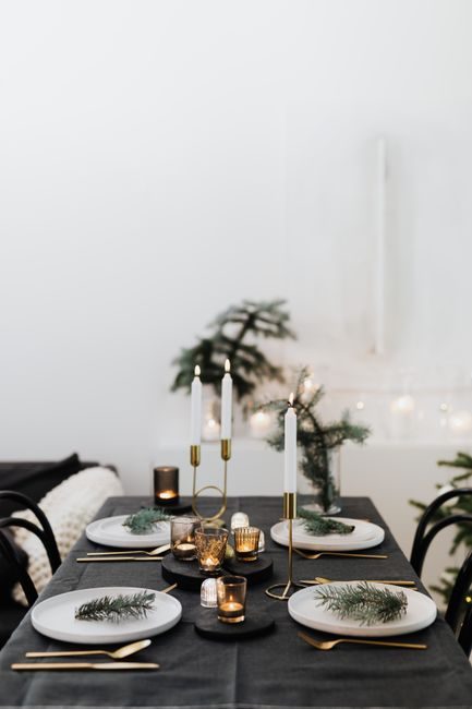 A beautifully set Christmas dining table with candles and elegant tableware for a festive occasion.