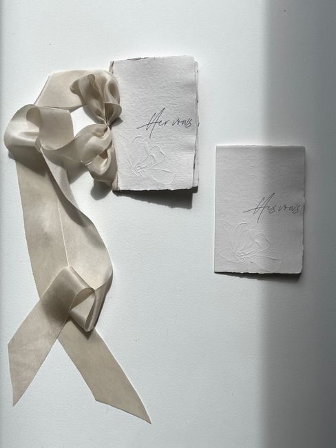 Minimalist wedding invitations and ribbon in dramatic light, perfect for elegant themes.